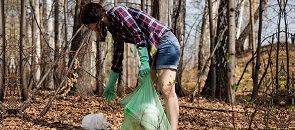 ragazza contribuisce a raccogliere l'immondizia nei boschi